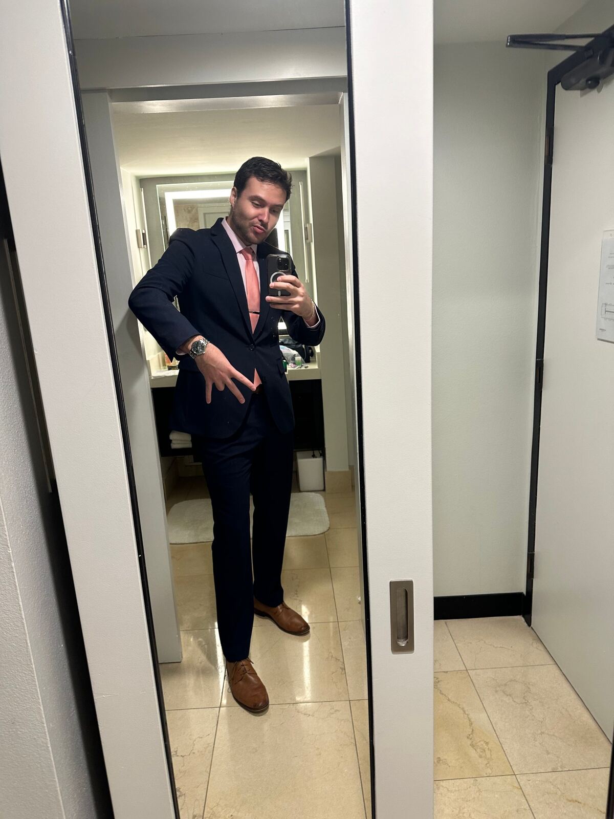 Mirror selfie in a navy suit and pink tie