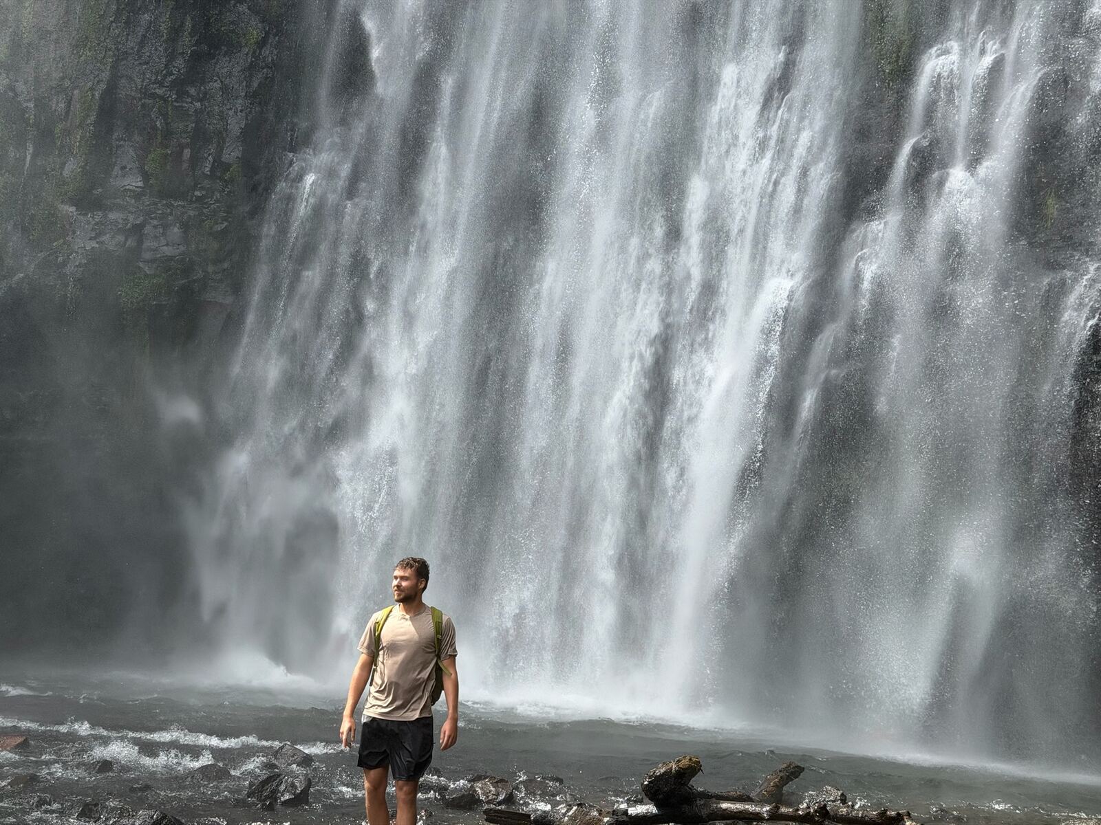 Elijah standing in front of a huge waterfall